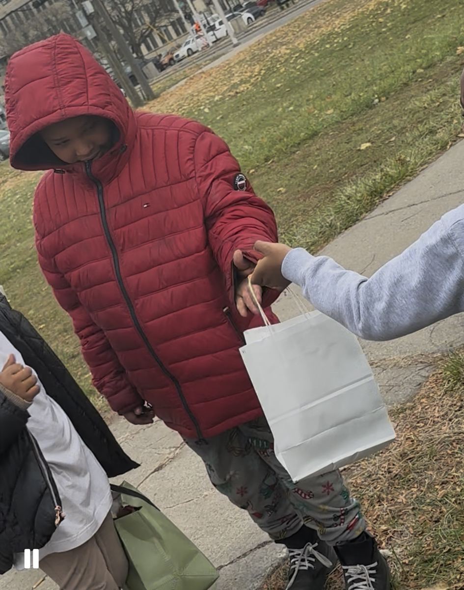 A community member receiving a gift bag outdoors