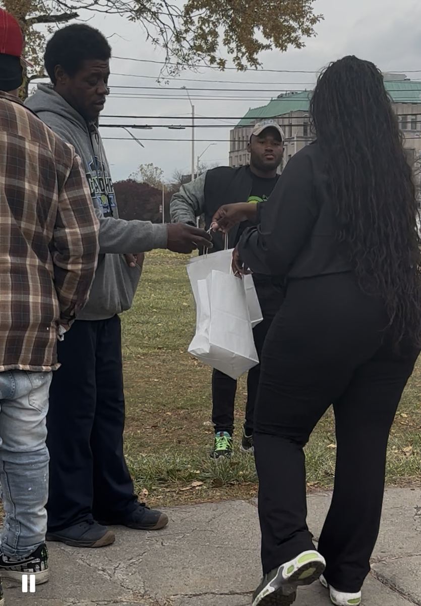 A volunteer handing out bags to community members